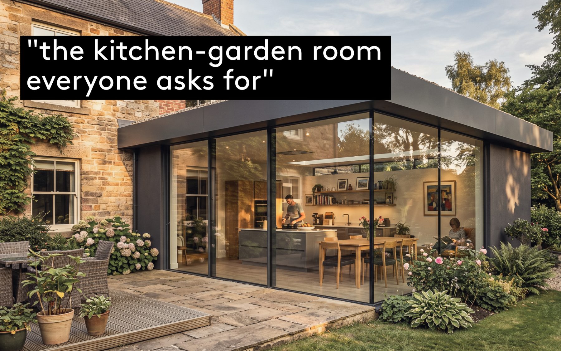 A contemporary glazed kitchen-garden extension with a slim dark-framed sliding wall, added to a Yorkshire stone house, opening onto a stone terrace and planted borders at dusk