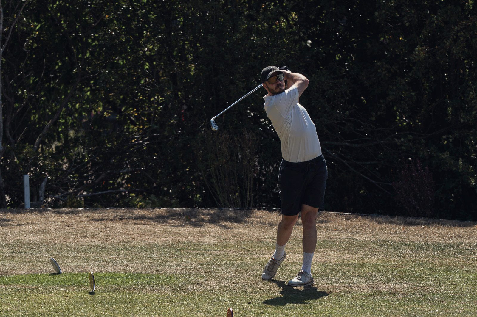 Jack at the top of his follow-through on the tee at Hanging Heaton, iron held high, ball already away