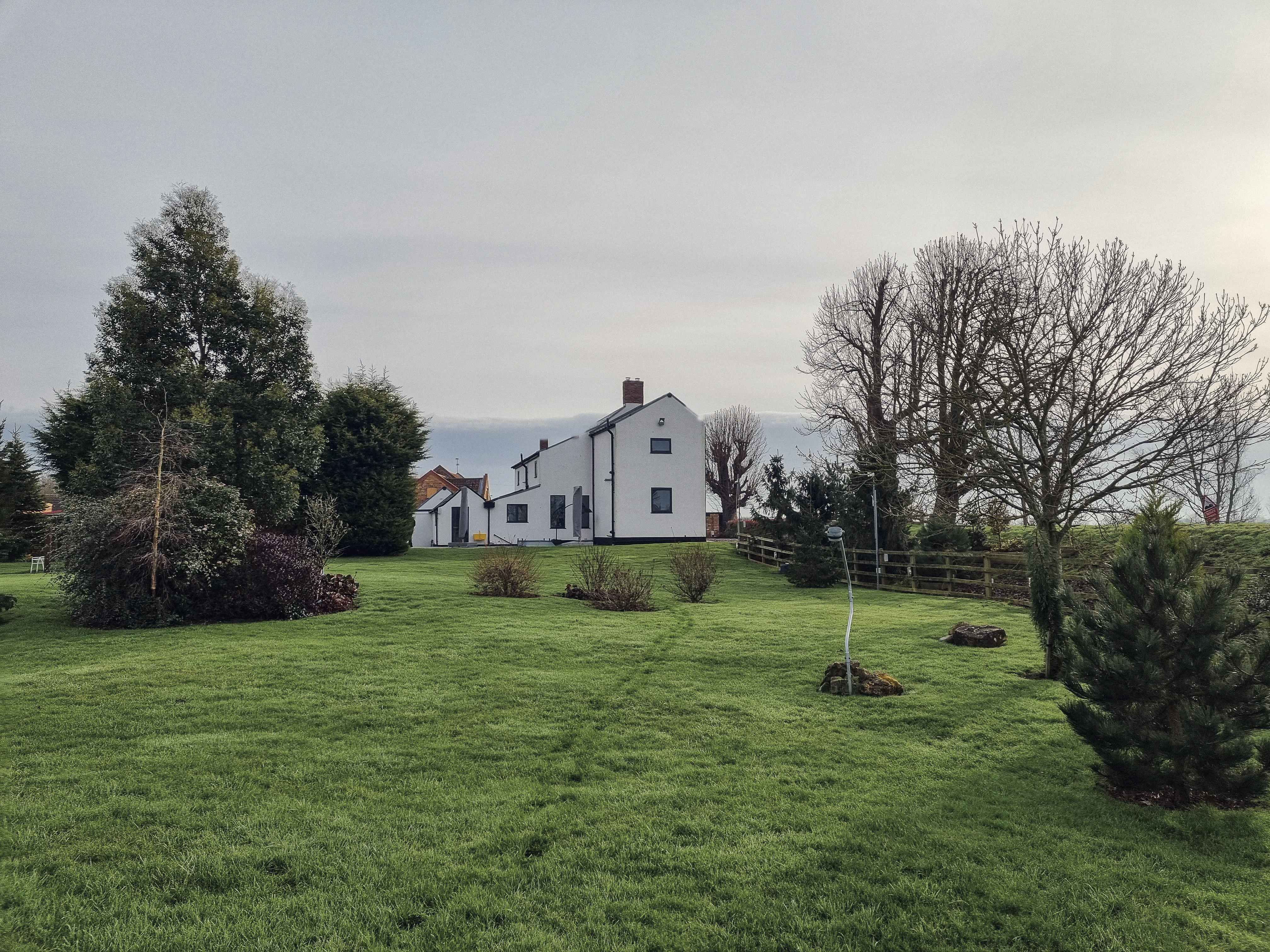 The oak-framed farmhouse in north Lincolnshire seen across its garden, showing the open rural landscape setting that shaped the planning strategy