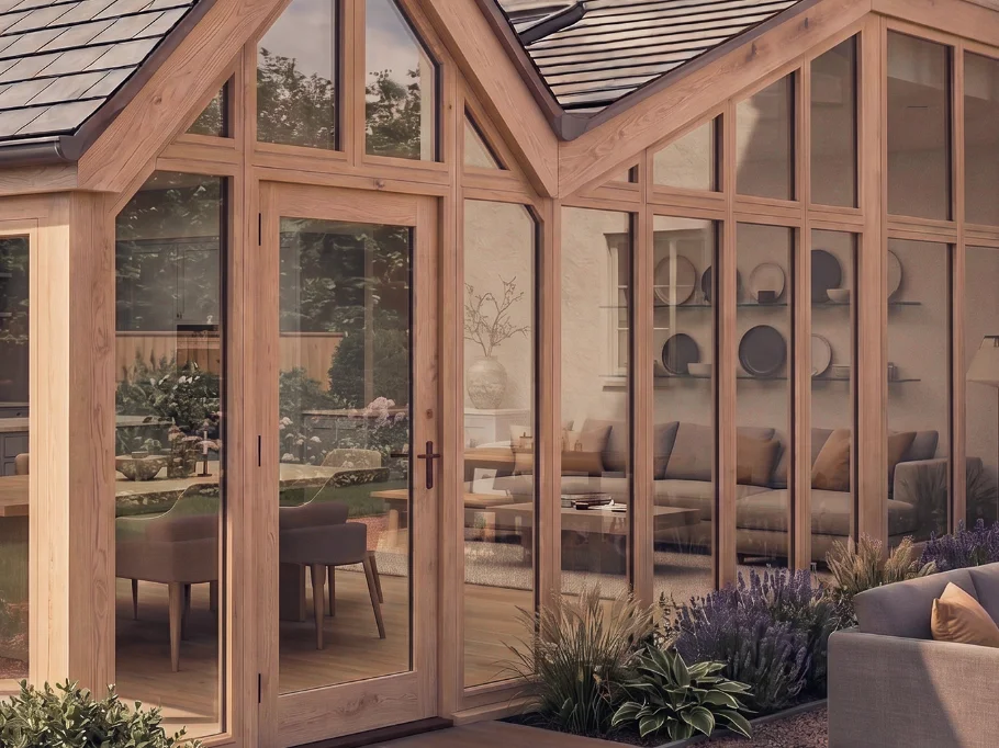 Floor-to-ceiling glazed rear wall of the farmhouse, looking from the open-plan dining space out to the terrace and lawns