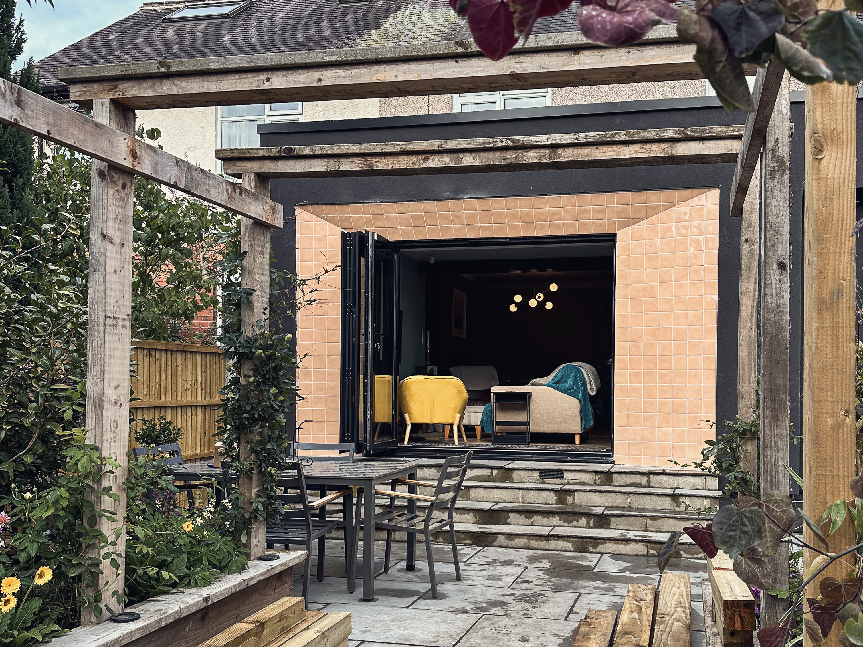 Black-framed bifold doors open onto natural stone flags and the garden of a rear extension in Roundhay, Leeds